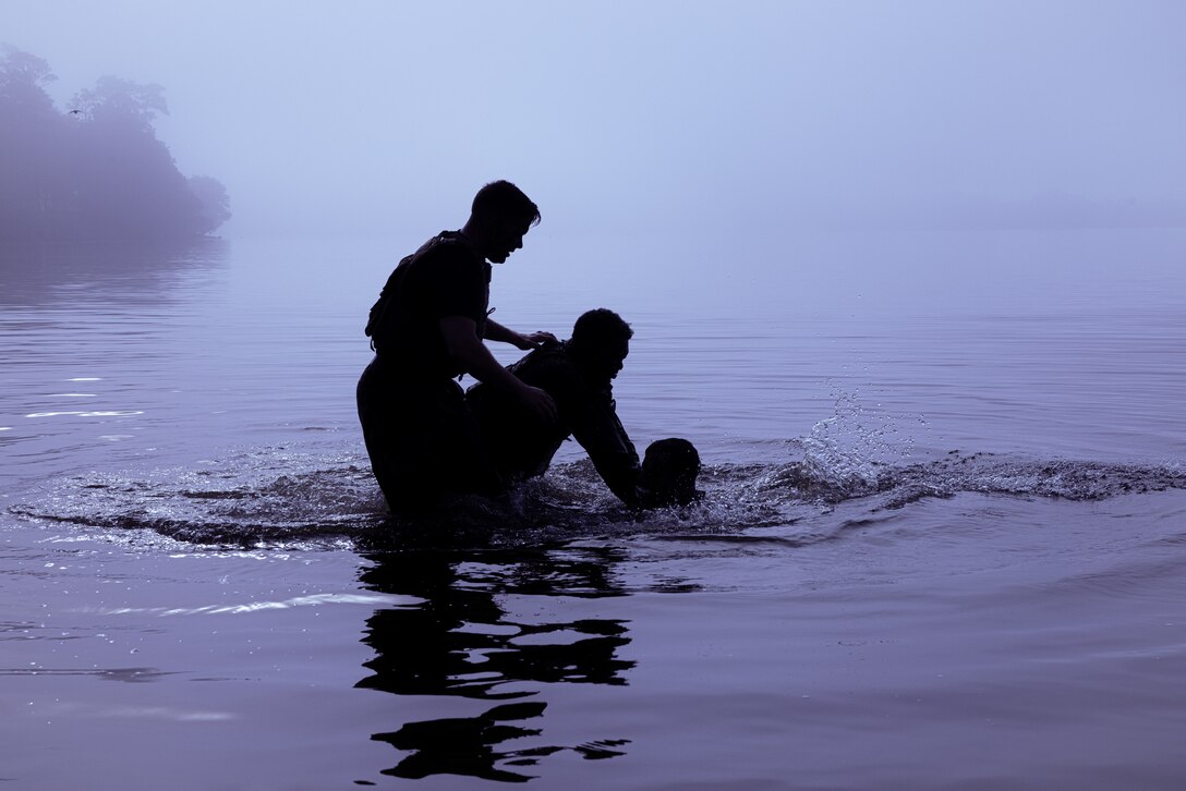 U.S. Marine Corps 1st Lt. Stewart Spurry, left, an infantry officer with 2nd Battalion, 2nd Marine Regiment, 2nd Marine Division, oversees Marines grappling in water during the culmination of Martial Arts Instructor Course (MAIC) 72-24 on Marine Corps Base Camp Lejeune, North Carolina, May 2, 2024. After three weeks of academic classes, advanced martial arts training and pushing their mental grit and physical toughness, Marines graduating MAIC 72-24 earned their ability to lead others in the Marine Corps Martial Arts Program. (U.S. Marine Corps photo by Lance Cpl. Loriann Dauscher)