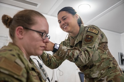 Air Force Audiologist performs exam