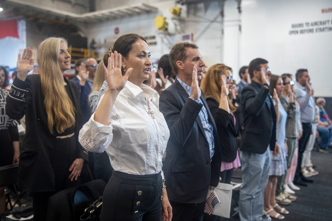 People from various countries recite the Oath of Allegiance during a naturalization ceremony held aboard the amphibious assault ship USS Bataan (LHD 5) at PortMiami, May 7, 2024, as a part of Fleet Week Miami. Fleet Weeks are a tradition of the U.S. Navy, Marine Corps and Coast Guard, where major U.S. cities host Marines, Sailors, and Coast Guardsmen for one week of community-wide events. Fleet Week Miami, in its first year, is an opportunity for residents and visitors to meet with service members, foster community relationships, and view the latest capabilities of today's maritime services. (U.S. Marine Corps photo by Cpl. Jacquilyn Davis)