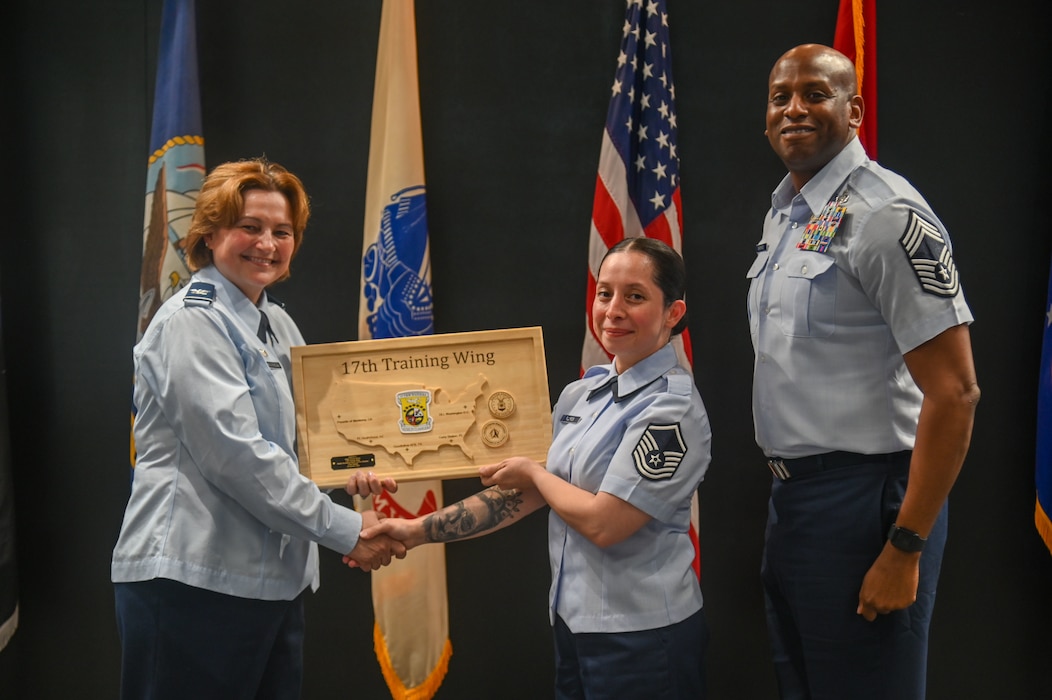 U.S. Air Force Col. Angelina Maguinness, 17th Training Wing commander, presents the Raider Excellence Senior Service Member of the quarter awards to Master Sgt. Victoria Flores, 17th Wing Staff Agencies, at the Powell Event Center, Goodfellow Air Force Base, Texas, May 3, 2024. The quarterly awards are a tradition that honors exceptional individuals for their outstanding contributions to the 17th TRW mission. (U.S. Air Force photo by Airman James Salellas)