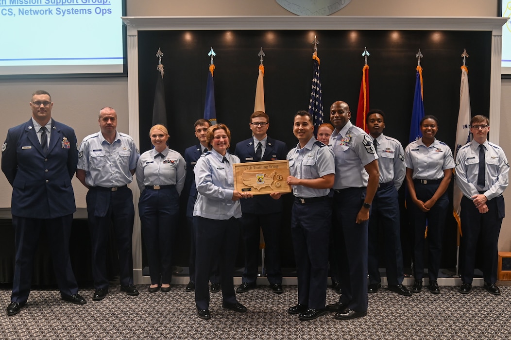 The 17th Communications Squadron-Network Systems Operations personnel pose with U.S. Air Force Col. Angelina Maguinness, 17th Training Wing commander and Chief Master Sgt. Derrick Sherrod, 17th Mission Support Group senior enlisted leader, as they receive their Team of the Quarter award at the Powell Event Center, Goodfellow Air Force Base, Texas, May 3, 2024. Quarterly awards are a tradition that honors exceptional individuals and units for their outstanding contributions to the 17th TRW mission. (U.S. Air Force photo by Airman James Salellas)