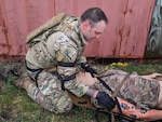 U.S. Air Force Master Sgt. Matthew Vandermolen, explosive ordnance disposal technician with the Wisconsin Air National Guard’s 115th Fighter Wing, prepares to transport an injured patient during a tactical combat casualty care exercise April 18, 2024, at Volk Field Air National Guard Base near Camp Douglas, Wisconsin. The training exercise was part of a 40 hour Tactical Combat Casualty Care - Combat Life Savers Course administered by members of the Wisconsin Air National Guard’s 115th Medical Group to Airmen within the wing who's career fields require advanced lifesaving skills. (U.S. Air National Guard photo by Senior Master Sgt. Paul Gorman)