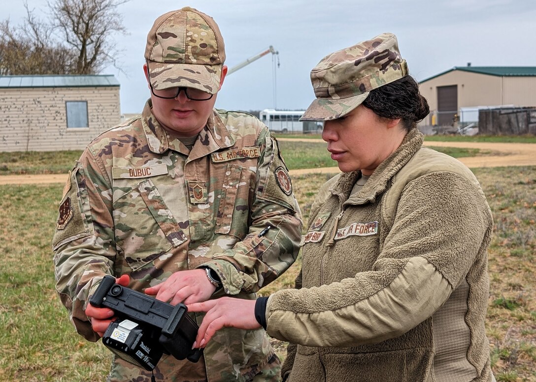 U.S. Air Force Master Sgt. David Dubuc and Tech. Sgt. Kailani Trainor-Bird, medical specialists assigned to the Wisconsin Air National Guard's 115th Fighter Wing, remotely operate a tactical combat patient simulator during a tactical combat casualty care exercise April 18, 2024, at Volk Field Air National Guard Base near Camp Douglas, Wisconsin. The training exercise was part of a 40 hour Tactical Combat Casualty Care - Combat Life Savers Course administered by members of the 115th Medical Group to Airmen within the wing who's career fields require advanced lifesaving skills. (U.S. Air National Guard photo by Senior Master Sgt. Paul Gorman)