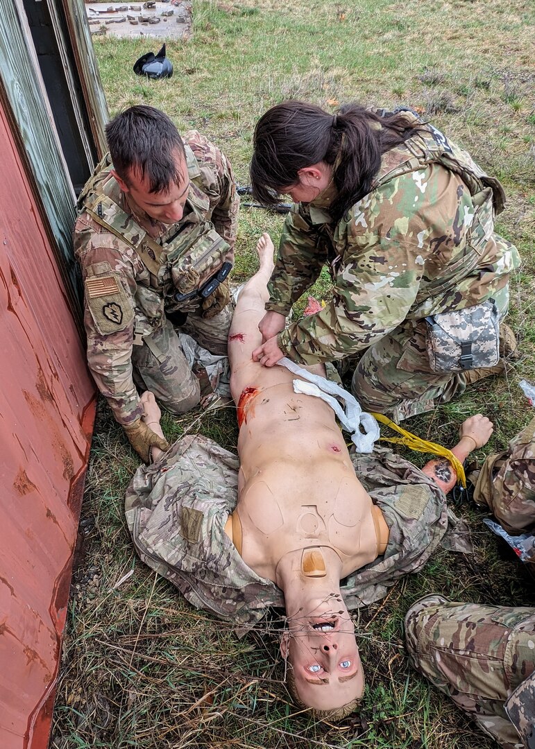 U.S. Air Force Master Sgt. Andrew Sireno, left, explosive ordnance disposal technician with the 115th Civil Engineer Squadron and Senior Airman Emily Jones, security forces specialist with the 115th Security Forces Squadron, work together to treat injuries on a tactical combat patient simulator during a tactical combat casualty care exercise April 18, 2024, at Volk Field Air National Guard Base near Camp Douglas, Wisconsin. The training exercise was part of a 40 hour Tactical Combat Casualty Care - Combat Life Savers Course administered by members of the Wisconsin Air National Guard’s 115th Fighter Wing Medical Group to Airmen within the wing who's career fields require advanced lifesaving skills. (U.S. Air National Guard photo by Senior Master Sgt. Paul Gorman)