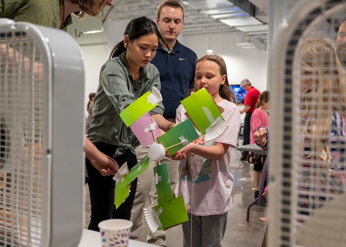 Students and teachers work on an art project to create a wind turbine.