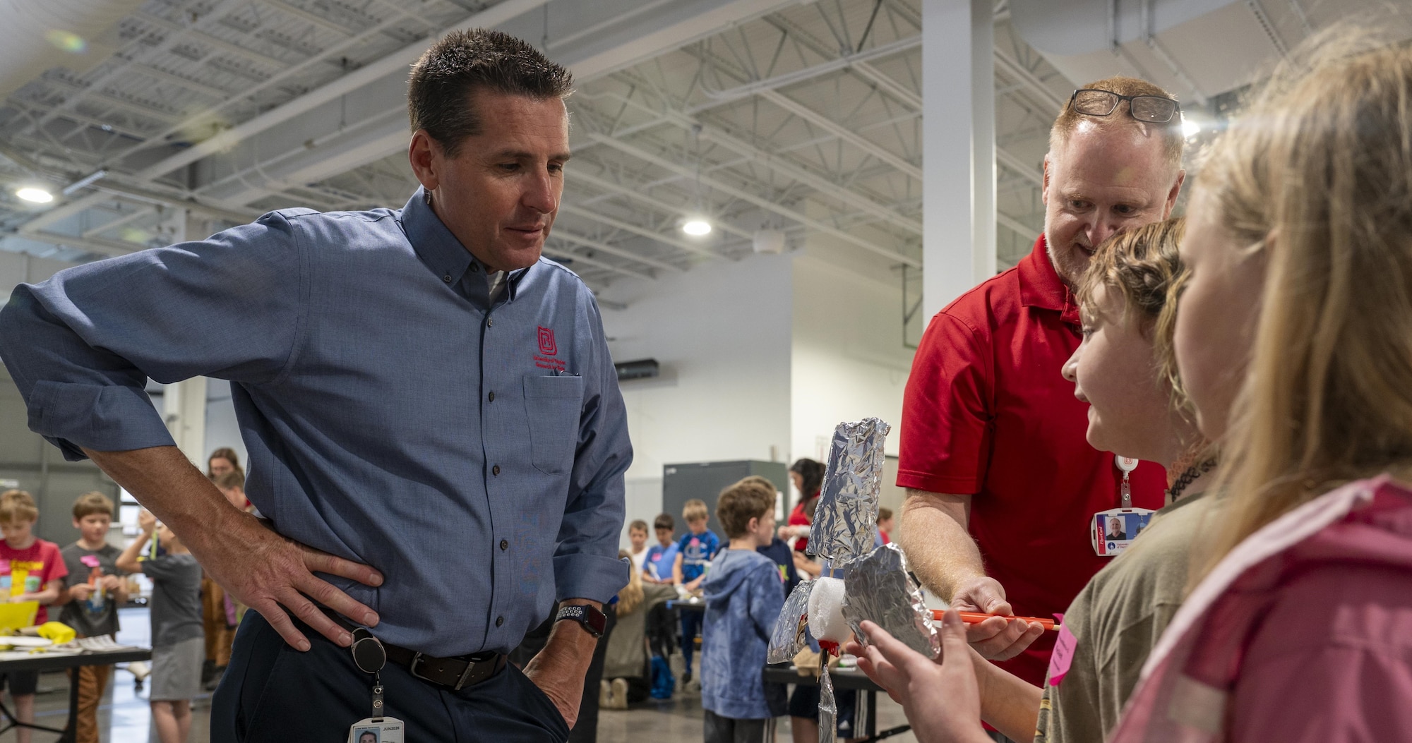 Engineers work with young students on wind turbines.