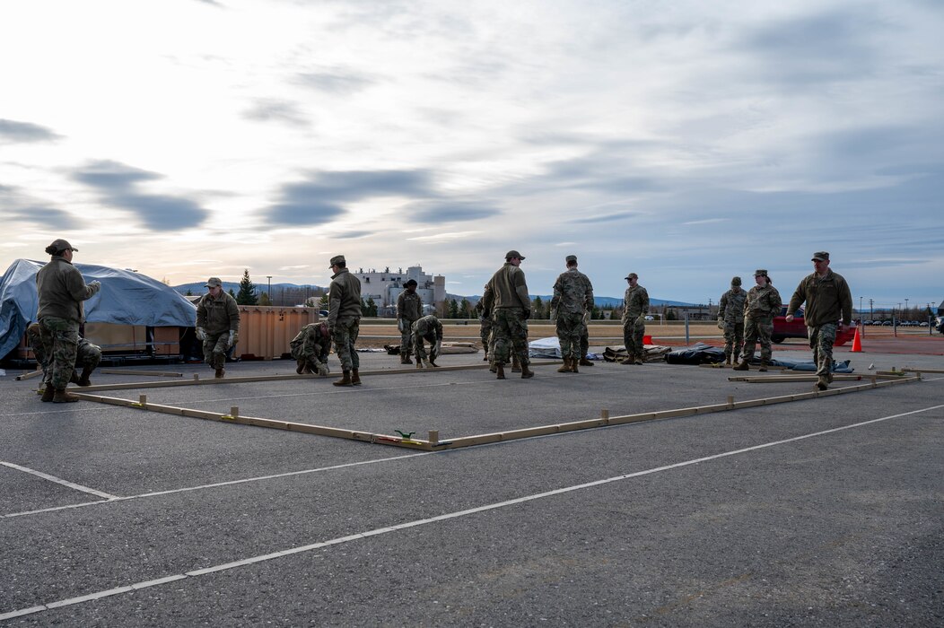 Airmen assigned to the 354th Force Support Squadron begin the construction of a tent during a Ready Raven Team exercise to bolster Agile Combat Employment at Eielson Air Force Base, Alaska, May 2, 2024.