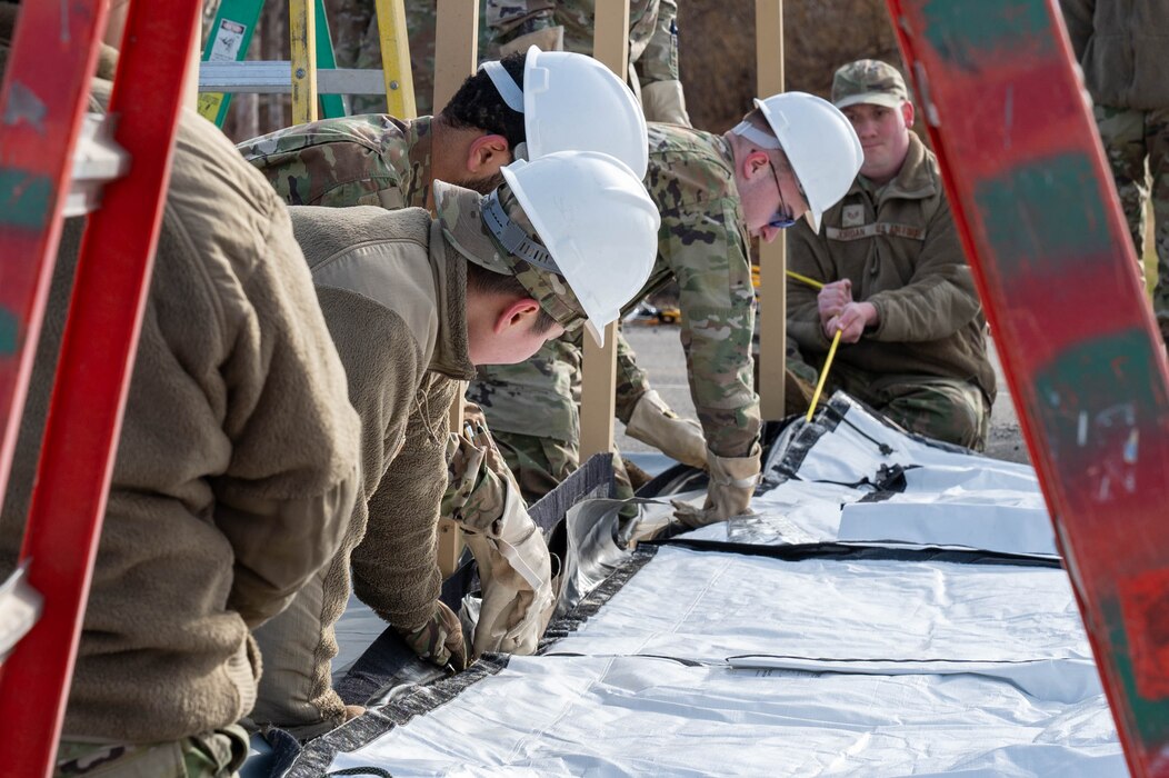 Airmen assigned to the 354th Force Support Squadron hook the bottom of tent cover during a Ready Raven Team exercise to bolster Agile Combat Employment at Eielson Air Force Base, Alaska, May 2, 2024.