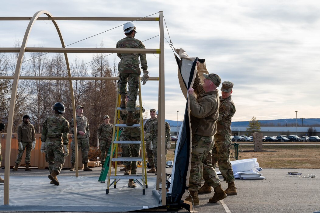 Airmen assigned to the 354th Force Support Squadron erect the back cover of a tent during a Ready Raven Team exercise to bolster Agile Combat Employment at Eielson Air Force Base, Alaska, May 2, 2024.