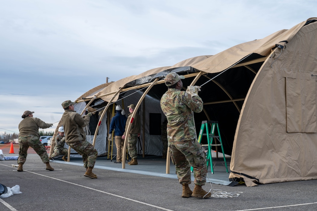 Airmen assigned to the 354th Force Support Squadron pull the top cover over a tent during a Ready Raven Team exercise to bolster Agile Combat Employment at Eielson Air Force Base, Alaska, May 2, 2024.