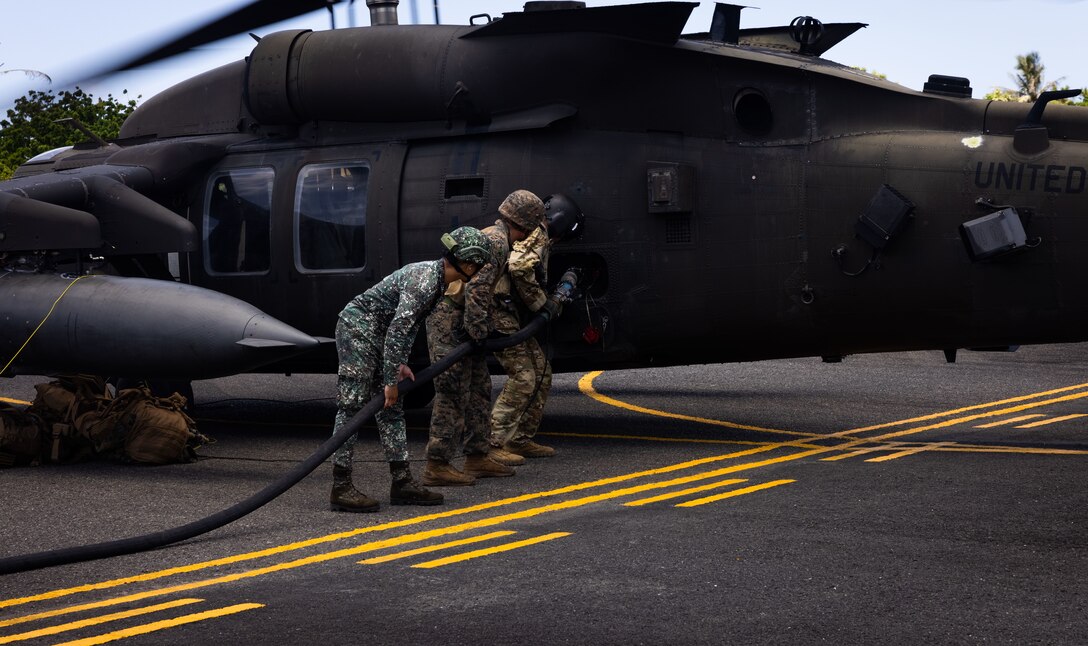 U.S. Marine Corps Cpl. Alexis Medina, an expeditionary fuel technician with Marine Wing Support Squadron 174, refuels a U.S. Army UH-60 Black Hawk helicopter as part of forward arming and refueling point operations alongside Philippine Marines, with Marine Battalion Landing Team 10, and U.S. Army soldiers during Balikatan 24 in Basco, Batanes Province, Philippines, April 30, 2024. BK 24 is an annual exercise between the Armed Forces of the Philippines and the U.S. military designed to strengthen bilateral interoperability, capabilities, trust, and cooperation built over decades of shared experiences. The Black Hawk helicopter is with the 225th Brigade Support Battalion, 2nd Infantry Brigade Combat Team, 25th Infantry Division. (U.S. Marine Corps photo by Sgt. Jennifer Andrade)