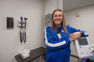 A woman poses in front on medical equipment.