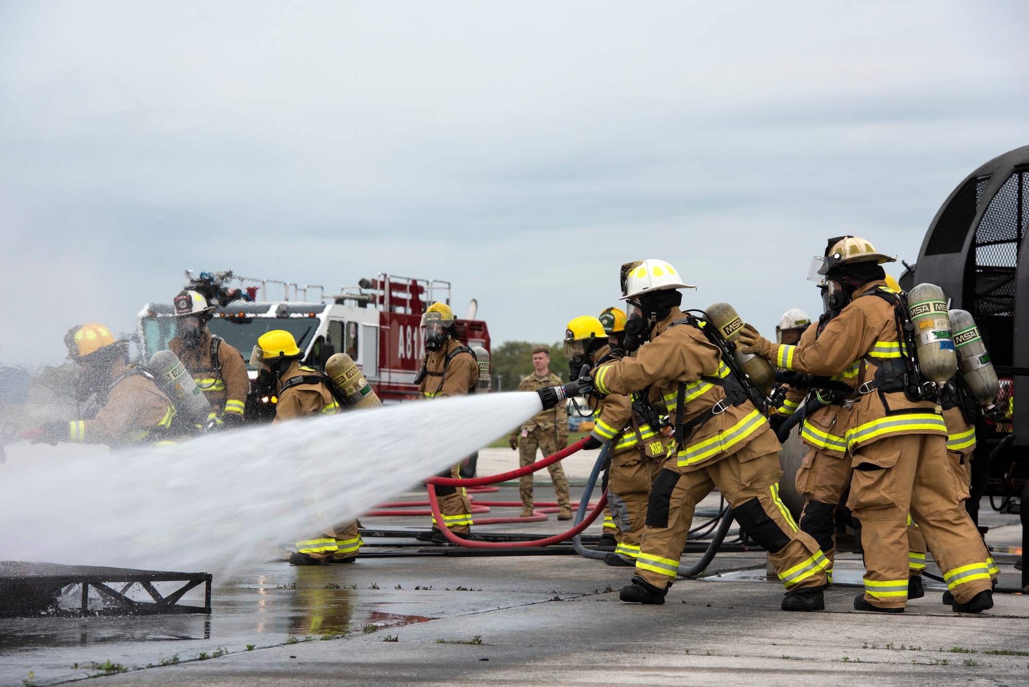 Firefighters spray flames with water.