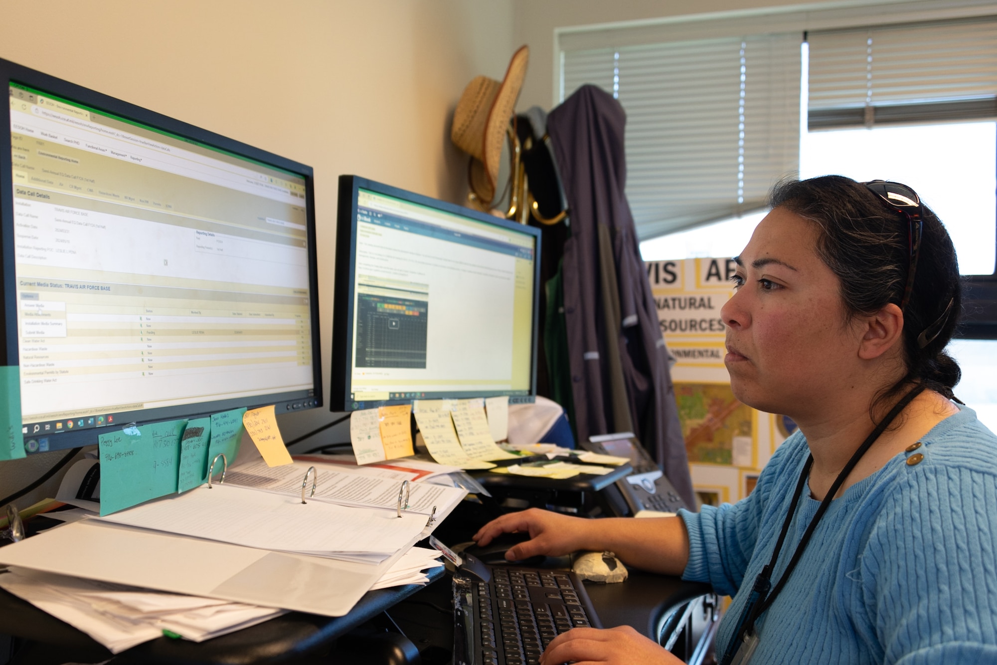 A woman works reads a computer screen at her desk.