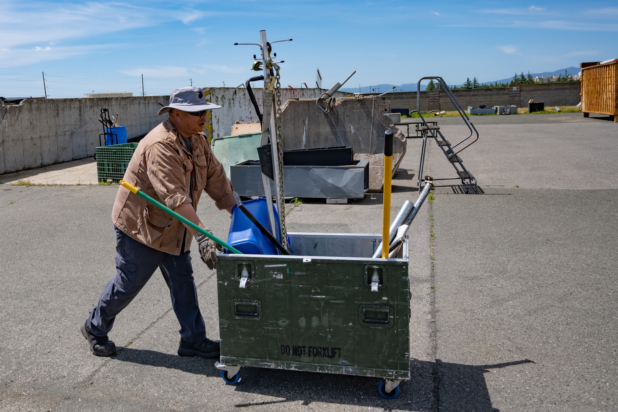 A man pushes a cart loaded with scrap metal.