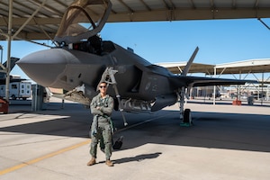 U.S. Air Force Capt. Garrett Ellis, 308th Fighter Squadron instructor pilot, poses in front of an F-35 Lightning II before conducting the 100,000th F-35 sortie at Luke Air Force Base, Arizona, May 9, 2024.