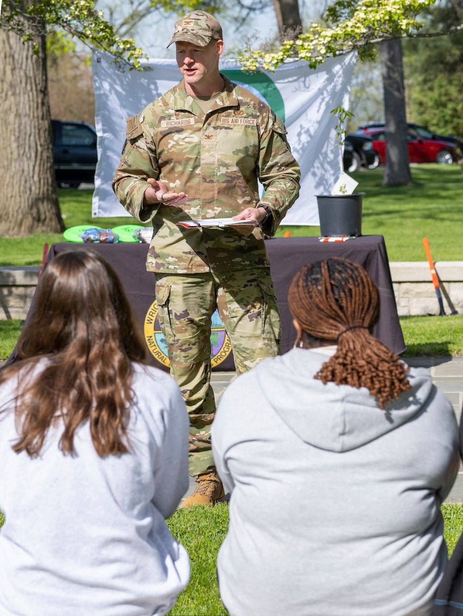 A man in uniform stand in front of students talking.
