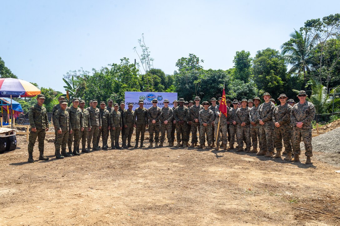 U.S. Marines with 9th Engineer Support Battalion, 3rd Marine Logistics Group, III Marine Expeditionary Force, pose alongside soldiers with the Philippine Army for a group photograph at the conclusion of a groundbreaking ceremony at Alannay Elementary School prior to the commencement of Exercise Balikatan 24 in Cagayan, Philippines, March 26, 2024. BK 24 is an annual exercise between the Armed Forces of the Philippines and U.S. military designed to strengthen bilateral interoperability, capabilities, trust, and cooperation built over decades of shared experiences. (U.S. Marine Corps photo by Cpl. Trent A. Henry)