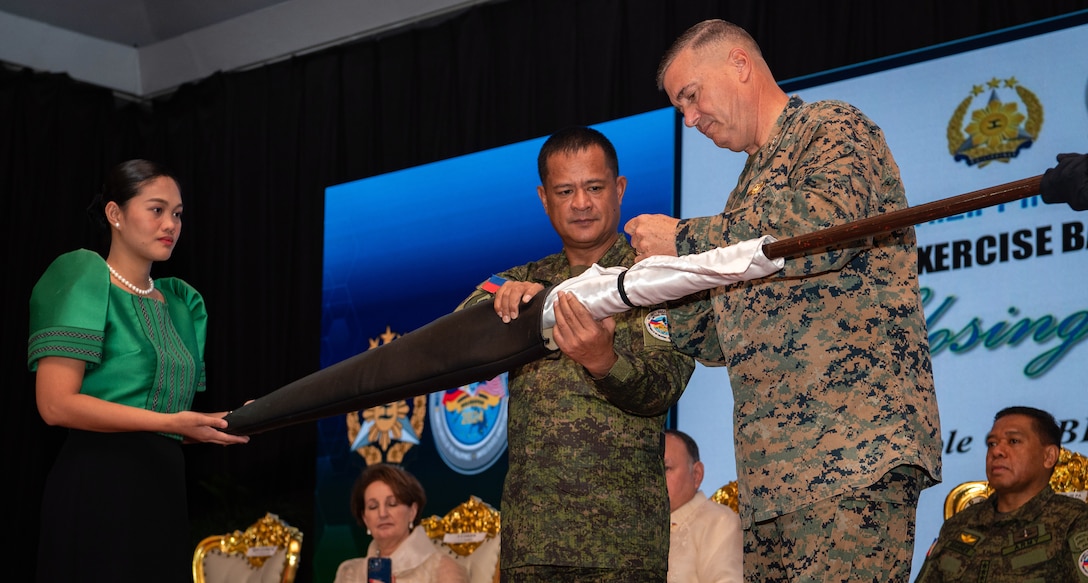 Armed Forces of the Philippines Maj. Gen. Marvin L Licudine, Philippines Exercise Director, and Lt. Gen. Michael S. Cederholm, U.S. Exercise Director representative and Commanding General, I Marine Expeditionary Force, furl the exercise flag during the closing ceremony to conclude Exercise Balikatan 24 at Camp Aguinaldo, Manila, Philippines, May 10, 2024. BK 24 is an annual exercise between the Armed Forces of the Philippines and the U.S. military designed to strengthen bilateral interoperability, capabilities, trust, and cooperation built over decades of shared experiences. (U.S. Air Force photo by Staff Sgt. Pedro Tenorio)