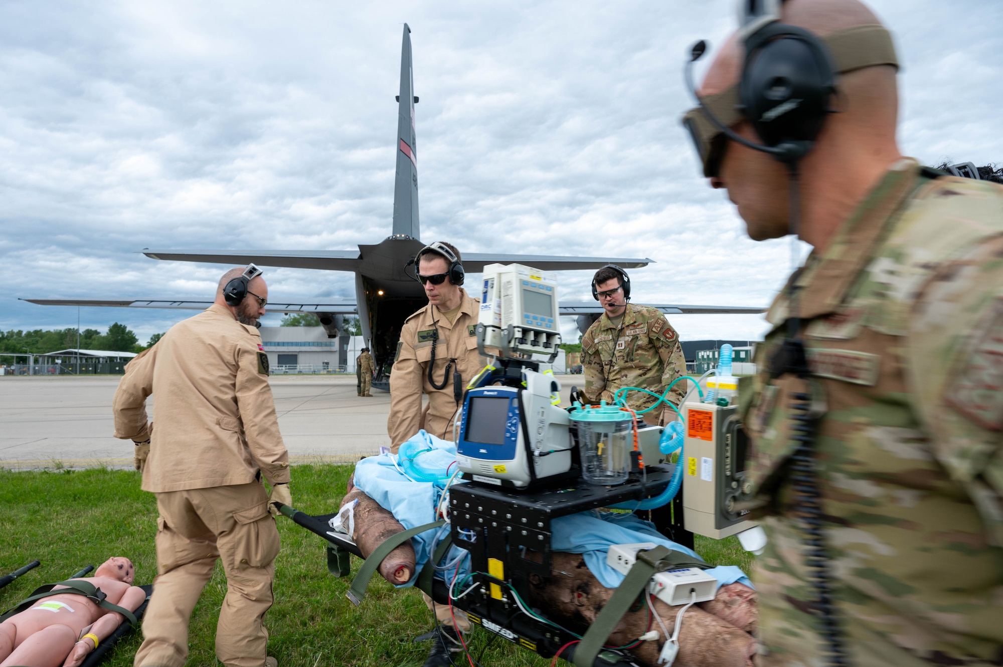 U.S. Air Force and Royal Norwegian AF members off-load a medical manikin from a C-130J Super Hercules aircraft at Papa Air Base, Hungary, May 7, 2024.