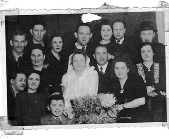 A monochrome photo of Connie Liss' parents (center) at their wedding with extended family. Liss recently spoke to members of the Strategic Systems Programs (SSP) workforce about her mother, Dina Rosenberg Jacobson, and Jacobson's experiences as a Holocaust survivor who was held for three years at Auschwitz. Her presentation was part of SSP's Special Emphasis Programs, which are employee-engagement programs that illuminate underrepresented groups and topics in an effort to highlight diversity within the workforce.