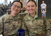 Army nurse Korean-born Capt. Hyekyong Nicholson smiles with her Army nurse daughter 1st Lt. Alayna Serr in a Joint Base San Antonio, Texas, dining facility three days after her May 4, 2022, graduation from the Basic Officer Leadership Course, at the Medical Center of Excellence there. Serr said she is thrilled to serve in the Army Nurse Corps alongside with her mother, now that she graduated from the nursing program at Indiana University, her mother's alma mater. Inset: In this undated photo, Nicholson stands with her daughter Alayna as the two wear Army physical training tee shirts. (Courtesy photos) (Sgt. 1st Class Neil W. McCabe)