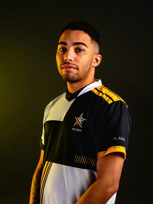 Man with a multi-colored polo standing in front of a black background.