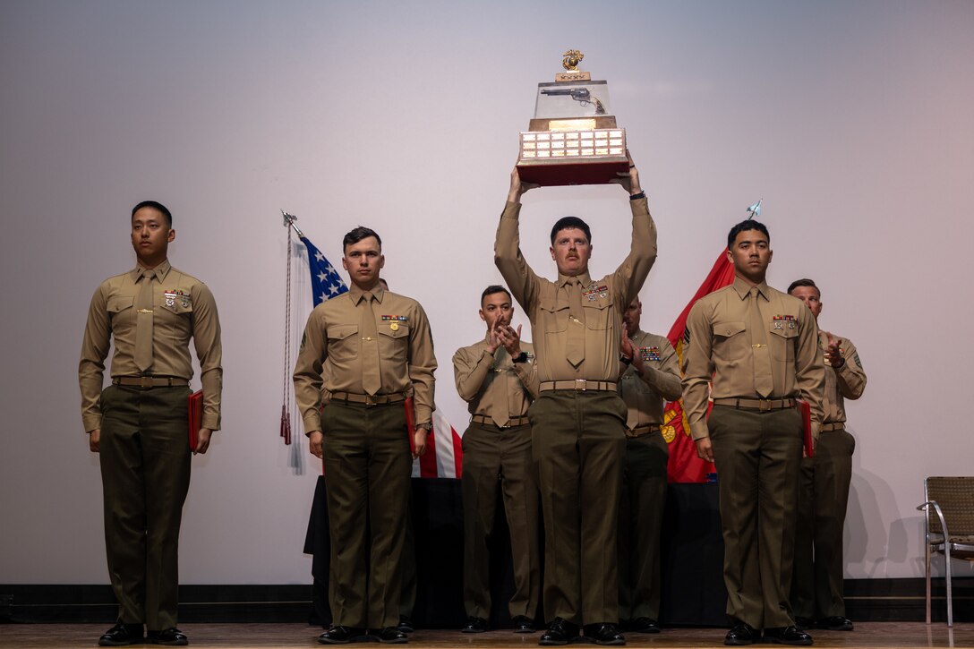 U.S. Marines with 1st Marine Logistics Group are presented the Holcomb Trophy for achieving the highest aggregate pistol scores during the Marine Corps Marksmanship Competition West on Camp Pendleton, California, Feb. 25, 2024. The award was created in honor of General Thomas Holcomb, the seventeenth Commandant of the Marine Corps, who was a member of the first Marine Corps competitive rifle team. MCMC West is one of four marksmanship competitions in the Marine Corps and provides advanced marksmanship training and competition to regional units in order to enhance proficiency and small arms lethality throughout the Marine Corps. (U.S. Marine Corps photo by Lance Cpl. Deja Rogers).