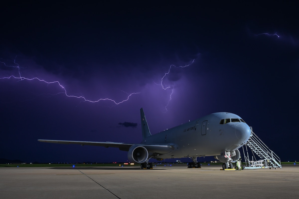 A KC-46 Pegasus sits on the flightline during a storm at Altus Air Force Base, Okla., April 30, 2024. Lightning filled the sky over Altus AFB and created a display of colors over the aircraft. (U.S. Air Force photo by Airman Lauren Torres)