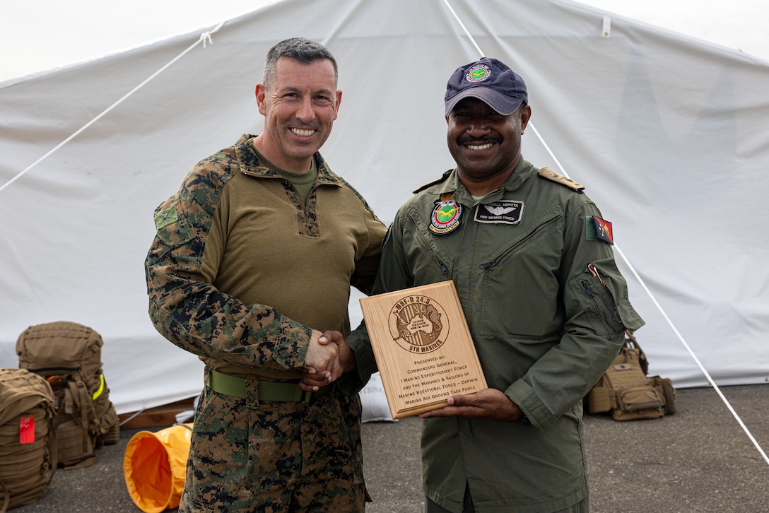 U.S. Marine Corps Col. Brian T. Mulvihill, left, the commanding officer of Marine Rotational Force – Darwin 24.3, poses for a photo with Papua New Guinea Defence Force Maj. Randall Hepota, the operations officer for the Air Transport Wing, PNGDF, during a humanitarian assistance and disaster relief exercise at the Air Transport Wing, Port Moresby, Papua New Guinea, May 8, 2024. The HADR exercise is conducted in coordination with the Papua New Guinea Defence Force and U.S. Embassy in Port Moresby, with a focus on projecting select role II medical, logistics, and Marine Air-Ground Task Force command and control capabilities off-continent, to validate HADR training and readiness. Mulvihill is a native of New York. (U.S. Marine Corps photo by Cpl. Juan Torres)