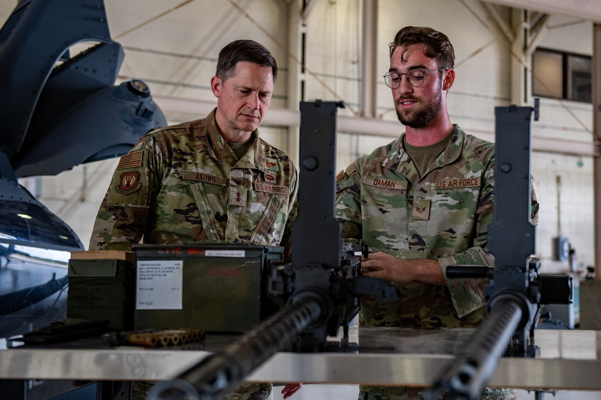 U.S. Air Force Senior Airman Darren Daman, 41st Rescue Squadron weapons load crew member, right, briefs Maj. Gen. David Lyons, Fifteenth Air Force commander, during a base tour at Moody Air Force Base, Georgia, May 2, 2024. During his visit, Lyons got a chance to meet with Airmen who enable Airpower every day, and learn about what they do to ensure the Flying Tigers can project agile airpower across the globe. (U.S. Air Force Photo by Senior Airman Courtney Sebastianelli)