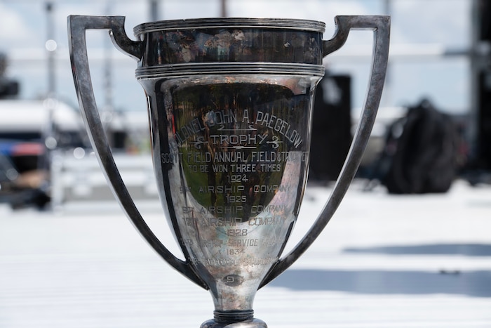 A silver trophy named The Squadron Cup sits on stage at a Wing Readiness Day competition.