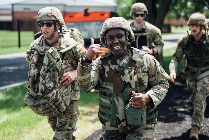 An airman smiles at camera while crossing the finish line during a base warrior challenge.