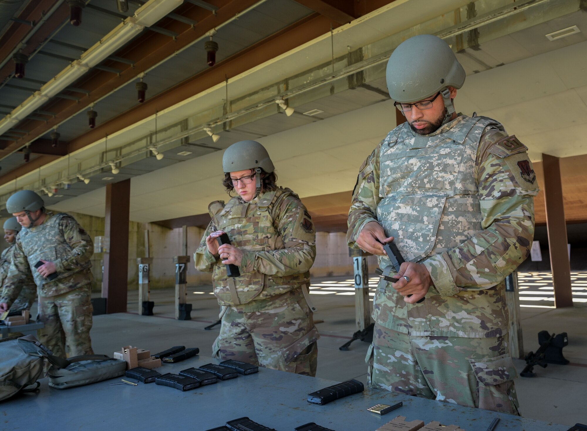 Airmen reloading magazines with ammo.
