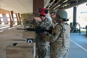 U.S. Air Force Senior Airman Ryan Caplinger, 633d Security Forces Squadron combat arms training and maintenance instructor, assists Staff Sgt. Kimberly Bradley, 700 Air Support Squadron command and control training technician, with adjusting the optic on an M-4 Carbine during a Combat Arms Training and Maintenance course at Joint Base Langley-Eustis, Virginia, May 1, 2024. Adjusting the optic is crucial to maintain accuracy, brevity, and efficiency when handling one’s firearm. (U.S. Air Force photo by Airman 1st Class Adisen Smith)