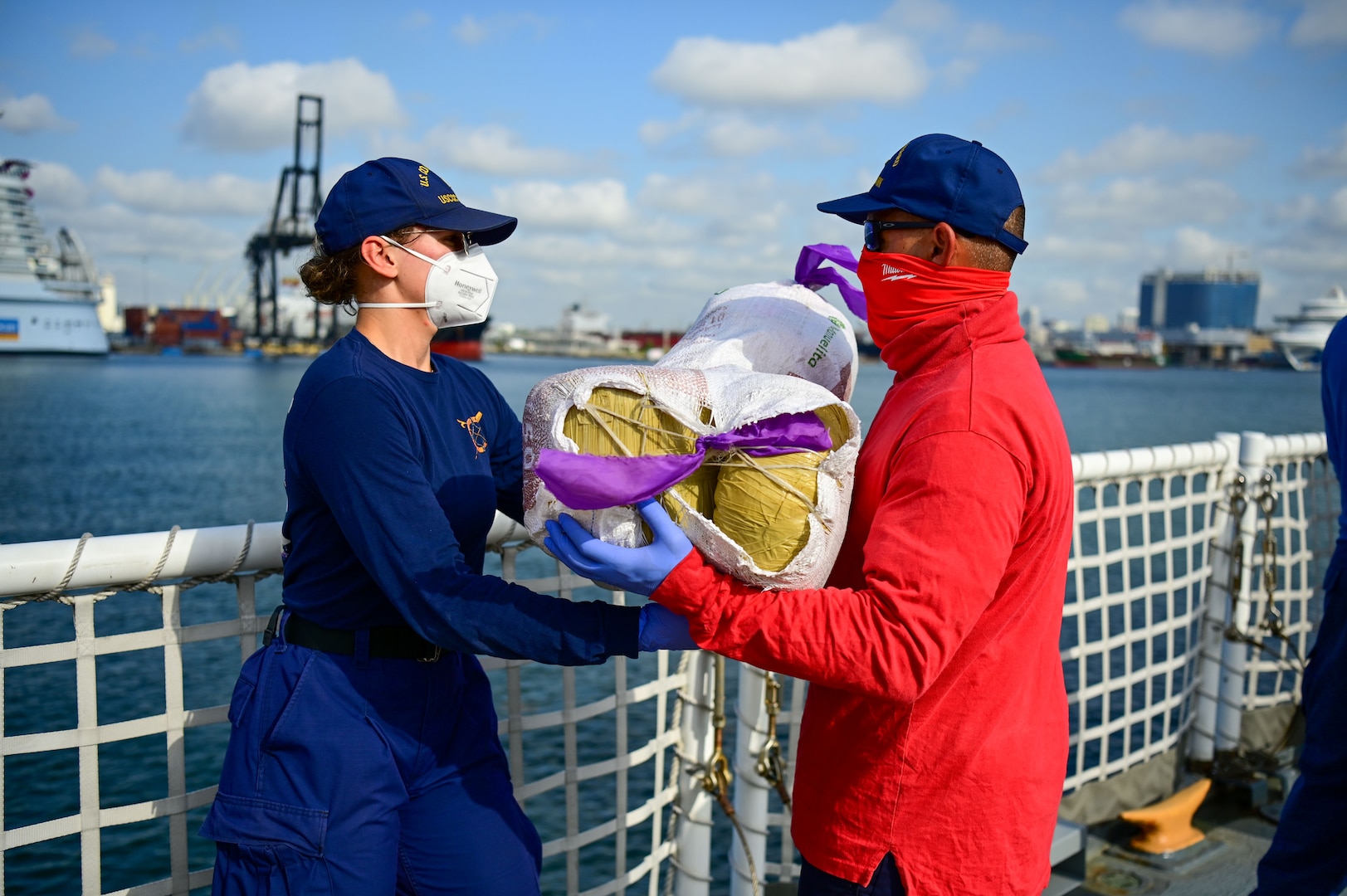 USCGC Mohawk (WMEC 913) crew members pass bales of illegal narcotics during a drug offload