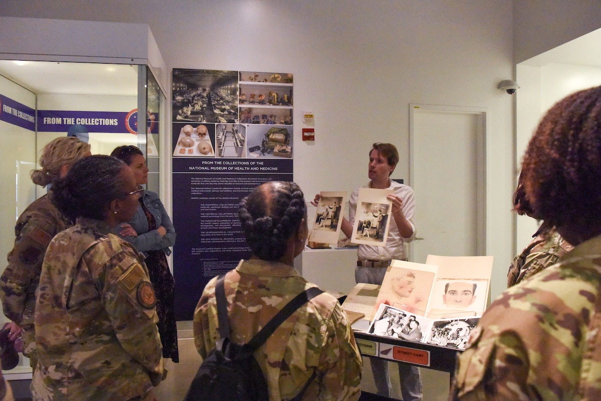 Image of Airmen listening to a person give a presentation.