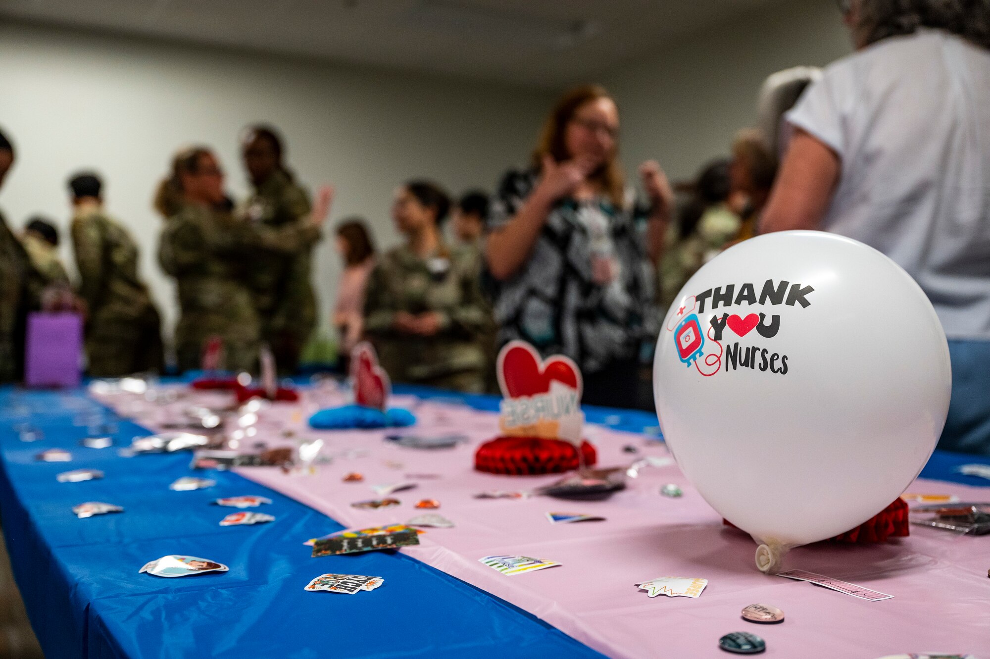 People converse around a table with a balloon and decorations.