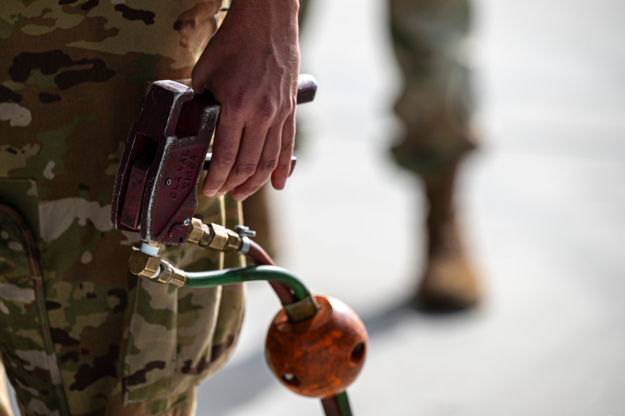 A servicemember holds a piece of equipment