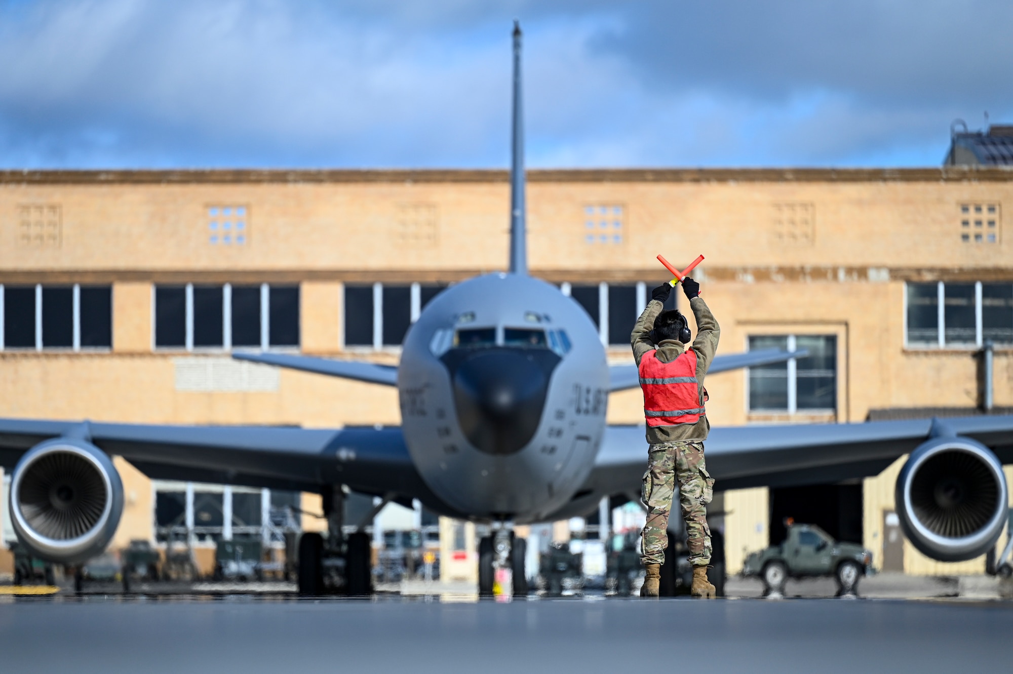 A servicemember marshals a plane