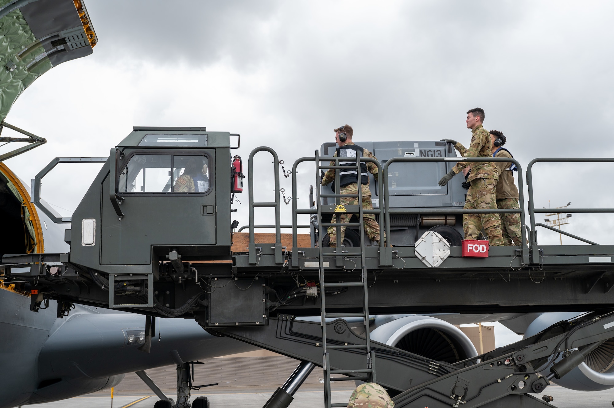 Servicemembers load cargo onto a plane