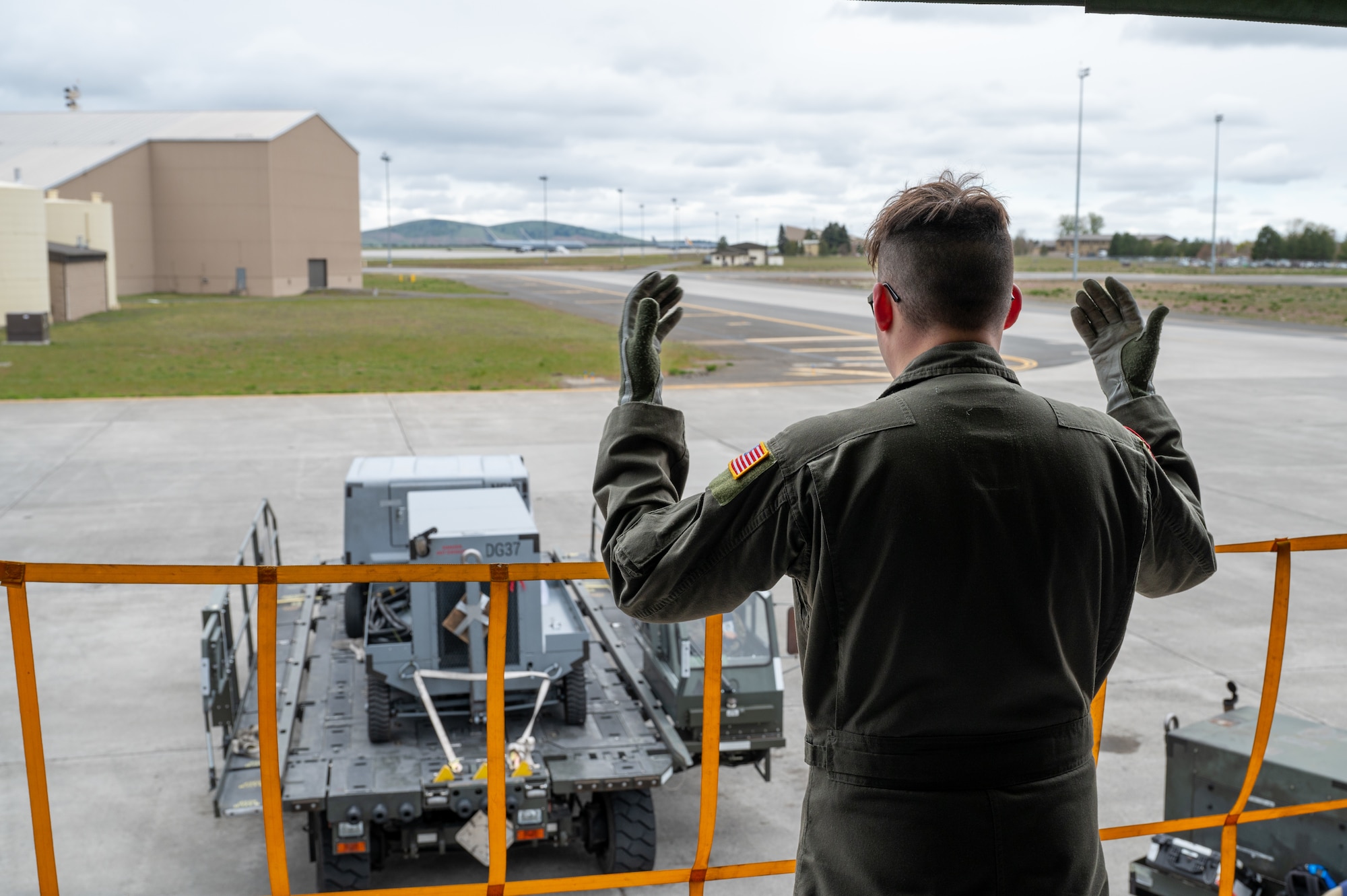 A servicemember guides a truck backing up