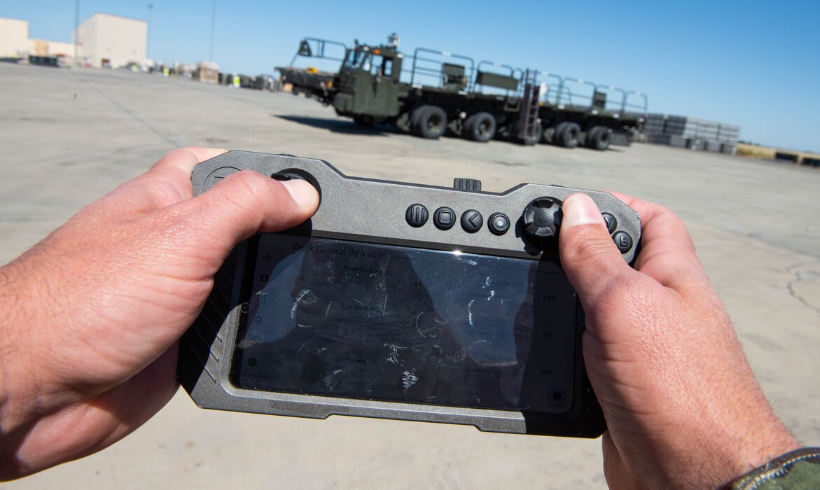 Airman's hands operating loader with a remote