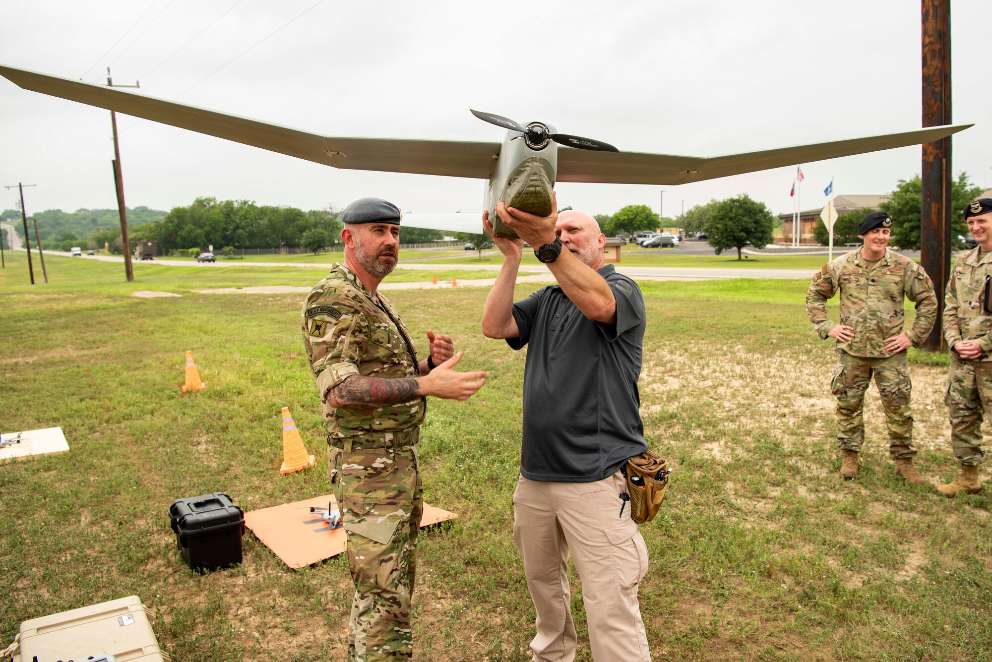 One individual holds an SUAS while the other looks on.