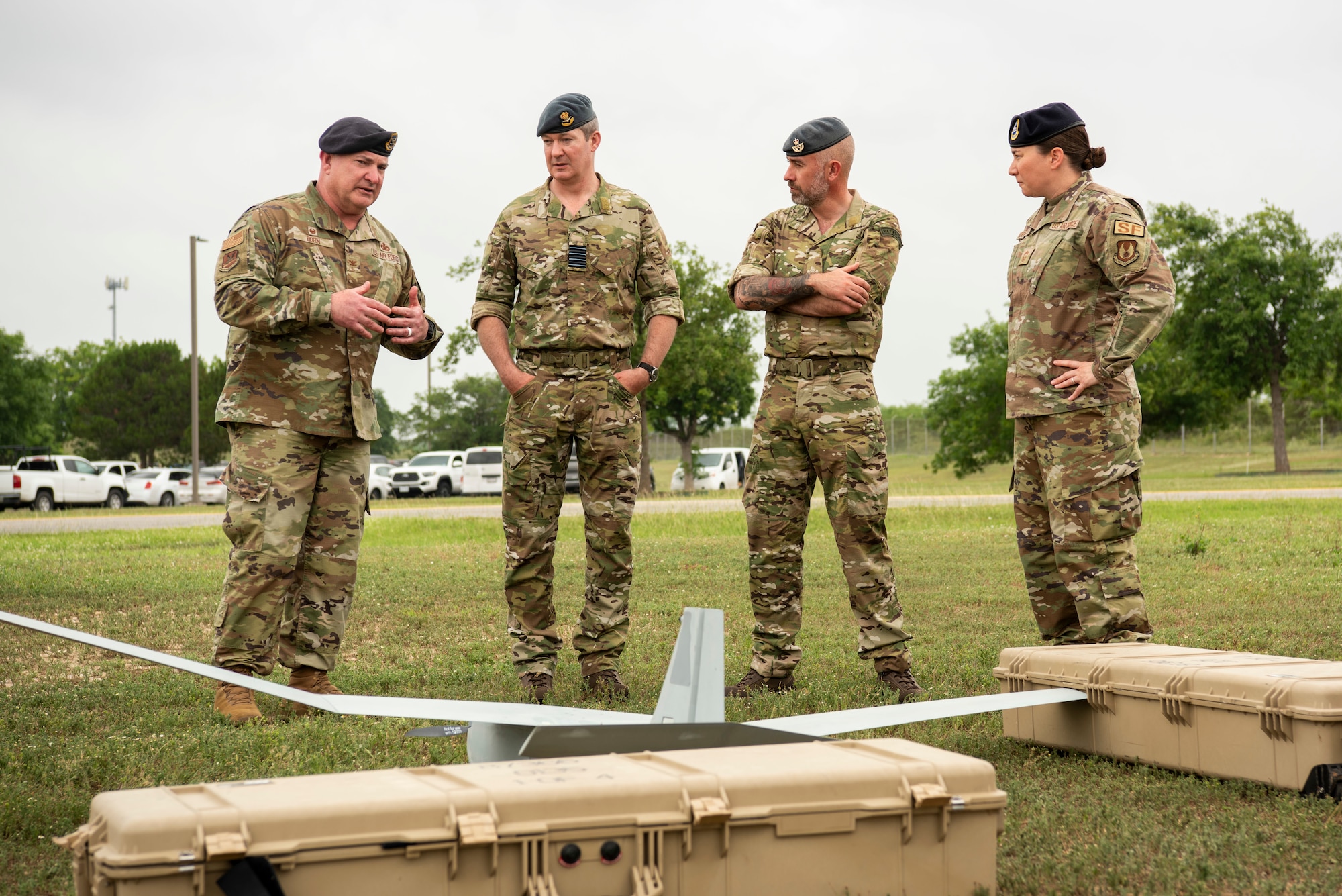 Four people talking with a SUAS in the foreground.
