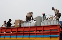 A photo of people loading trucks.