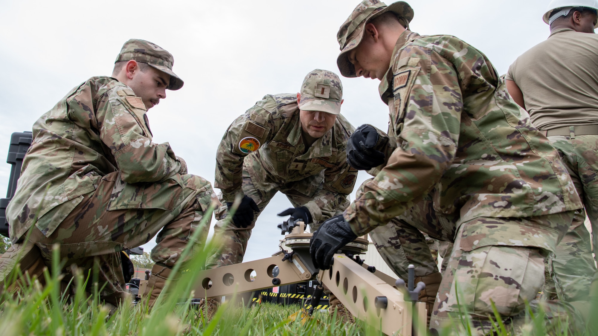 A team of U.S. Air National Guard Airmen work together to erect a portable satellite receiver.