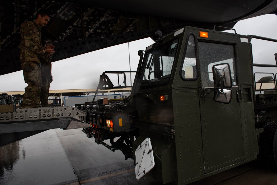 Airman guides a loader into position