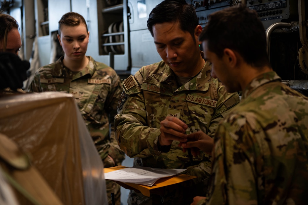 Airman sign documents on aircraft.