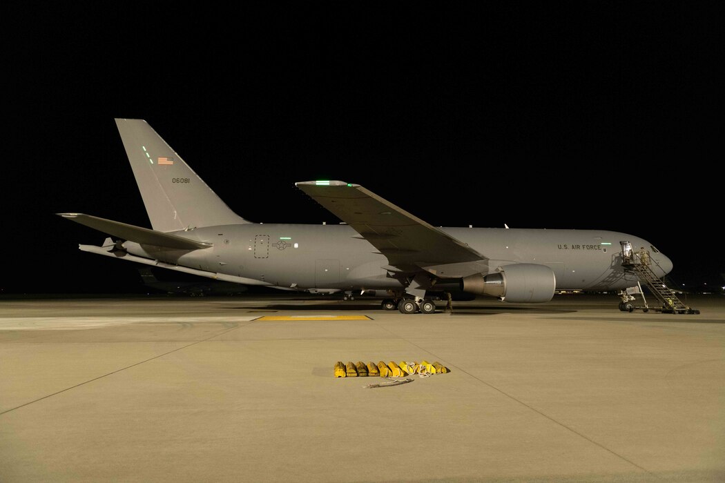 A KC-46A Pegasus aircraft sit on the flightline at night